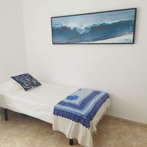 łóżko w pokoju ze zdjęciem na ścianie w obiekcie #SienteELSUR w mieście Barbate