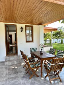 een houten tafel en stoelen op een patio bij Villa Misli - red/ green in Ortaca