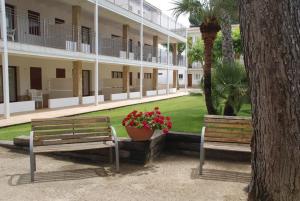 two park benches in front of a building at Apartaments Margarita Sabina Pinell in Platja d'Aro