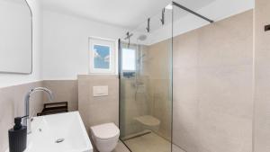 ein Badezimmer mit Glasdusche und Toilette in der Unterkunft Villa Saini with Sea View in Dajla + 35 Fotos