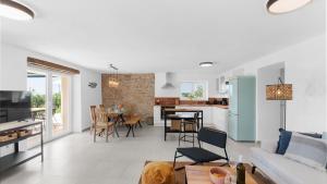 ein Wohnzimmer und eine Küche mit einer Couch und einem Tisch in der Unterkunft Villa Saini with Sea View in Dajla