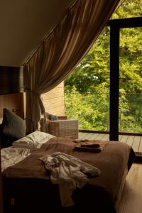 a bed in a bedroom with a large window at Campo Resort in Duszniki Zdrój