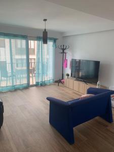 a living room with a blue couch and a flat screen tv at Apartamento Avenida Principal II in Altea