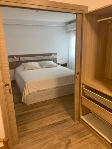 1 dormitorio con cama y espejo grande en Apartamento Avenida Principal II, en Altea