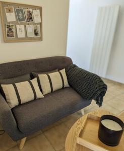 un sofá con una manta en la sala de estar en Plume, en LʼIsle-sur-la-Sorgue