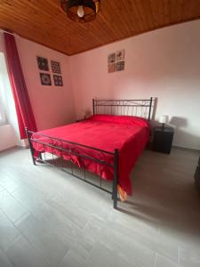 a bedroom with a red bed with a red blanket at Appartamento TERESA in Rio nellʼElba