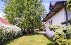 a yard next to a white house with trees at Beautiful Home In Grzybowo With 3 Bedrooms And Wifi in Grzybowo