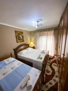 sypialnia z 2 łóżkami i żyrandolem w obiekcie KASMI home w mieście Kruja