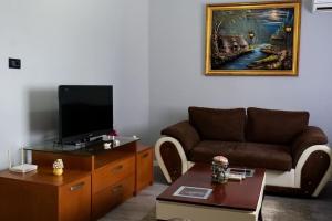 a living room with a couch and a tv at KASMI home in Krujë