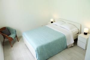 奧爾塔的住宿－Casa do Bairro，一间卧室配有一张大床和一把椅子