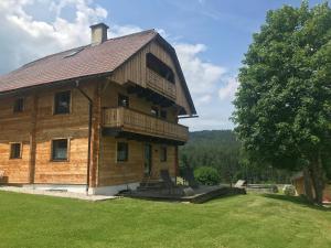 a large wooden building with a balcony on top at Chalet Reiterhäusl in Ramsau am Dachstein