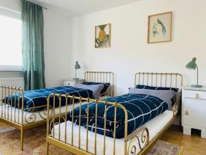 two beds sitting next to each other in a bedroom at Helle große Wohnung mit grandiosem Ausblick, Terrasse und Balkon in Bühlertal