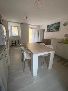 a kitchen and living room with a white table and chairs at Appartamento TERESA in Rio nellʼElba