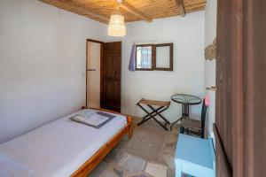 a bedroom with a bed and a table and a chair at AKTI ARGO in Palaiokastro
