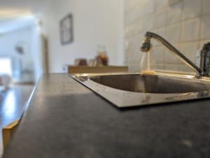 um lavatório de cozinha com água a jorrar de uma torneira em Plume em LʼIsle-sur-la-Sorgue