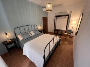 a bedroom with a bed and a chair and a mirror at Casale Gemma Solaris in Marsiliana