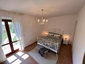 1 dormitorio con cama y lámpara de araña en Casale Gemma Solaris, en Marsiliana