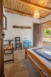 1 dormitorio con 1 cama, mesa y sillas en AKTI ARGO, en Palaiokastro