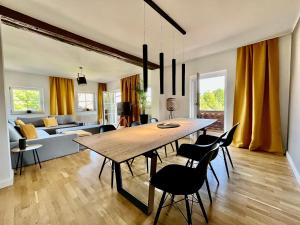 a dining room and living room with a table and chairs at STAYBEST Apartment König Ludwig in Prien am Chiemsee