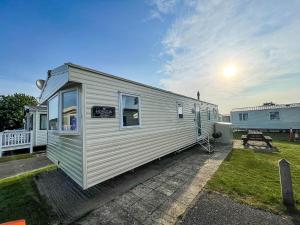 un pequeño remolque blanco estacionado en un patio en Superb 8 Berth Caravan At Caister Beach In Norfolk Ref 30073f en Great Yarmouth