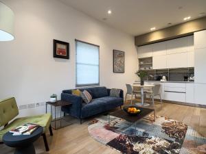 a living room with a couch and a table at Mirabilis Apartments - Bayham Street in London