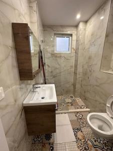 een badkamer met een wastafel en een toilet bij Arkadia Saranda in Sarandë