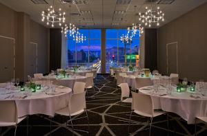 a banquet room with white tables and chairs and chandeliers at Graduate Tempe in Tempe