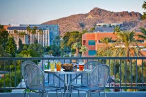 a table and chairs on a balcony with a view of a city at Graduate Tempe in Tempe
