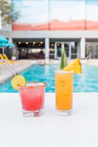 two cocktails sitting on a table next to a pool at Graduate Tempe in Tempe