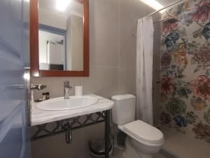 a bathroom with a sink and a toilet and a mirror at Taletos Apartments in Stoupa