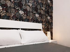 sypialnia z łóżkiem i tapetą w kwiaty w obiekcie B&B Università w Katanii