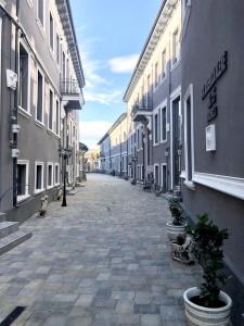 an empty street with buildings and potted plants at Cozy Central Studio Near Park in Bucharest