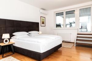 um quarto com uma grande cama branca e uma janela em Hotel Sandwirth em Klagenfurt