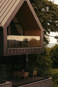 una casa con un balcón con un banco. en Campo Resort en Duszniki Zdrój