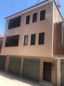 a white building with a bunch of garage doors at Ronaldo's Apartment in Pogradec