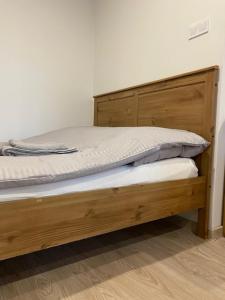 ミコワイキにあるNowe - Apartamenty Sunset Mikołajkiの木製フレームの木製ベッド1台が備わるベッドルーム1室が備わります。
