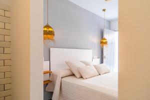 a bedroom with a white bed with two pillows at Calas De Meca in Los Caños de Meca