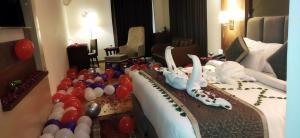 a hotel room with a cake and balloons on a bed at The Park Regency Hotel in Moga