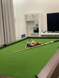 a room with a pool table with cue balls on it at Al Fay Farmhouse in Sinādil