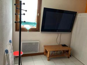 TV de pantalla plana en la esquina de una habitación en L'Appart D'Alice, en Bernex