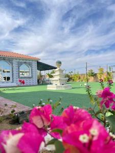 a garden with a statue in the middle of a yard at Al Fay Farmhouse in Sinādil