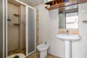 a bathroom with a sink and a toilet and a mirror at Geranio in Caserío Bacarot
