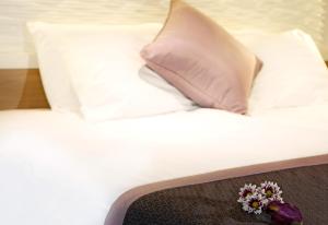een wit bed met een kussen en bloemen erop bij Crowne Plaza Limassol, an IHG Hotel in Limassol