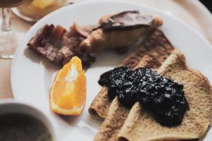 un piatto bianco di prodotti per la colazione con pane tostato e frutta di Hotell Lappland a Lycksele