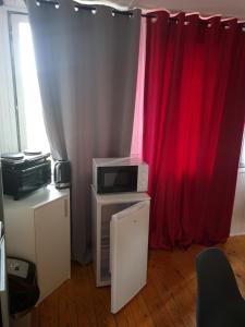 a room with red curtains and a microwave at Domek Wakacyjny Patrycja 47 in Głębokie