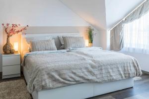 a white bedroom with a large bed and a window at Haus Seeblick Wohnung 16 in Wohlenberg