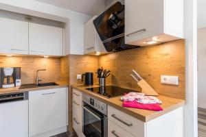 a kitchen with white cabinets and a counter top at Haus Seeblick Wohnung 16 in Wohlenberg