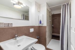 a bathroom with a sink and a toilet and a shower at Haus Seeblick Wohnung 16 in Wohlenberg