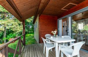 a patio with a white table and chairs on a deck at Camping de La Vernhe in Saint-Amans-des-Cots