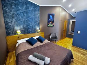 een slaapkamer met een groot bed met een blauwe muur bij DK Apartament w Centrum in Olsztyn